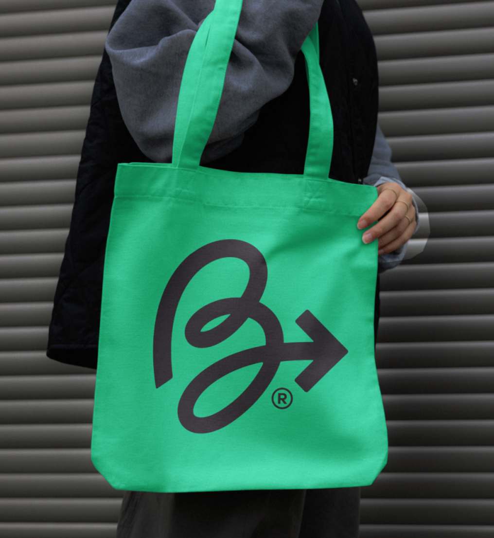Person moving forward with Byewaste green tote bag